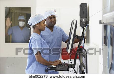 Stock Photograph - African American medical professionals looking at computer. Fotosearch