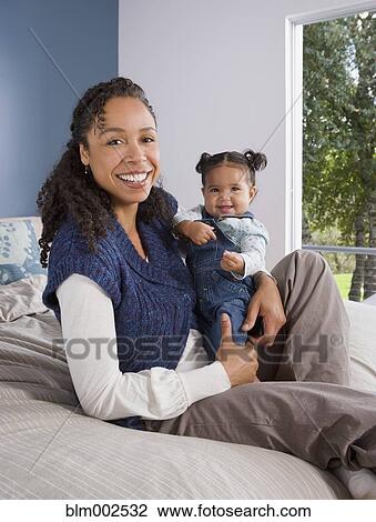 Stock Image - African American mother holding baby. Fotosearch