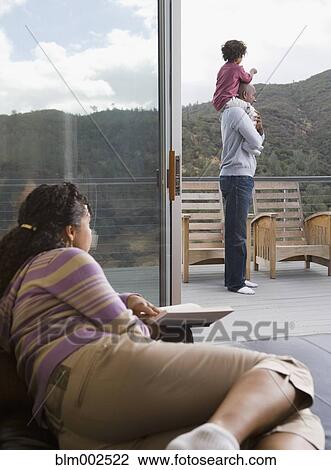 Stock Image - African American mother watching father and son on deck. Fotosearch