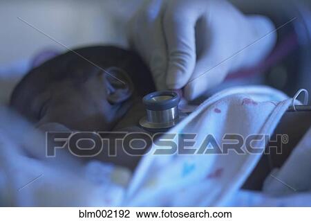 Stock Image - African American premature baby being examined. Fotosearch