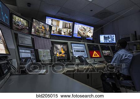 Stock Photography - African American security officer working in control room. Fotosearch