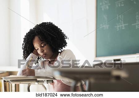 Picture - African American student writing in classroom. Fotosearch