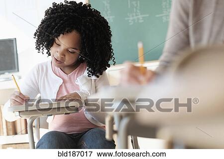 Stock Photo - African American student writing in classroom. Fotosearch