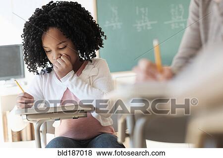 Stock Photo - African American student writing in classroom. Fotosearch