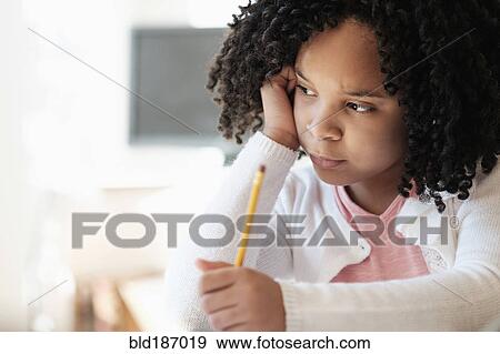 Stock Photo - African American student writing in classroom. Fotosearch