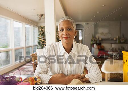 African American woman sitting at table View Large Photo Image Stock Photograph - African American woman sitting at table. Fotosearch