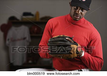 African baseball player holding glove in locker room View Large Photo Image Stock Photo - African baseball player holding glove in locker room. Fotosearch