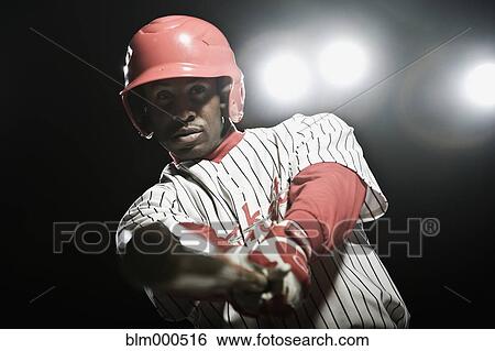Stock Photograph - African baseball player swinging bat. Fotosearch