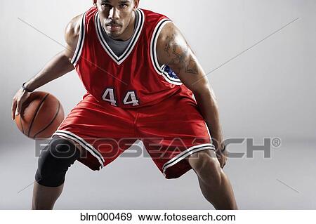 Stock Photo - African basketball player bounding basketball. Fotosearch