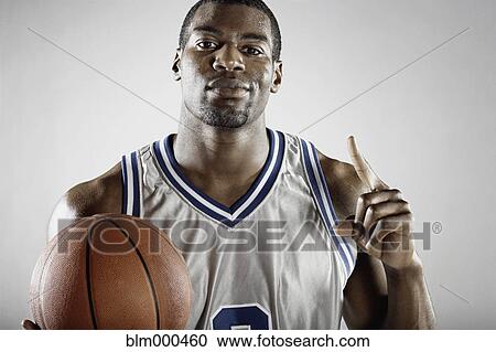 Stock Image - African basketball player holding basketball. Fotosearch