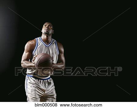 Stock Photo - African basketball player holding basketball. Fotosearch