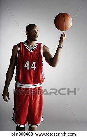 Stock Photo - African basketball player spinning basketball. Fotosearch