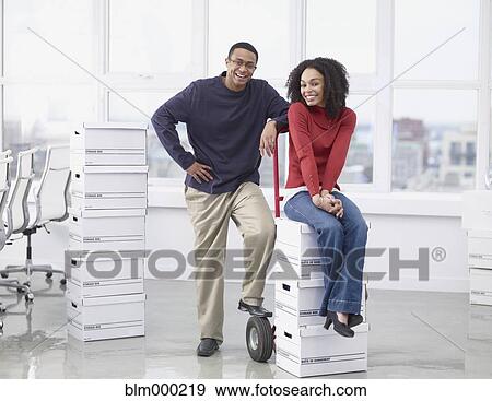 Stock Photo - African business people with boxes in new office. Fotosearch