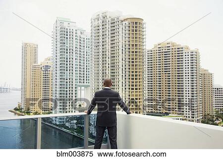 African businessman looking at city from urban balcony View Large Photo Image Stock Photography - African businessman looking at city from urban balcony. Fotosearch