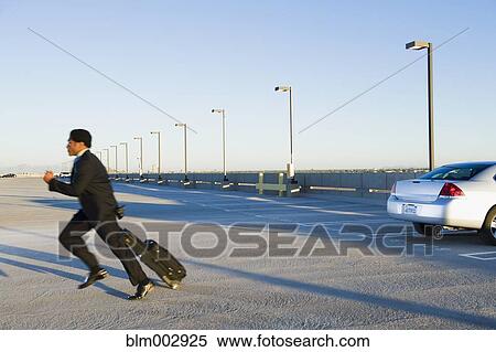 Stock Photography - African businessman running to catch plane at airport. Fotosearch
