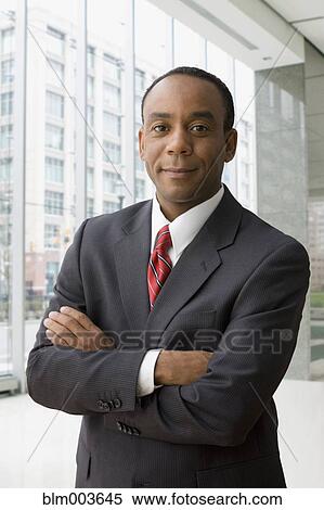 Stock Photography - African businessman standing with arms crossed. Fotosearch