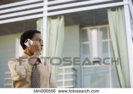 Stock Photograph - African businessman talking on cell phone. Fotosearch