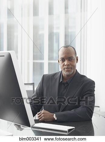 African businessman working on computer in office View Large Photo Image Stock Image - African businessman working on computer in office. Fotosearch