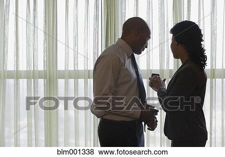Stock Photo - African businesspeople looking at cell phone. Fotosearch