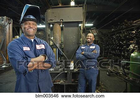 Stock Photograph - African co-workers in repair shop. Fotosearch