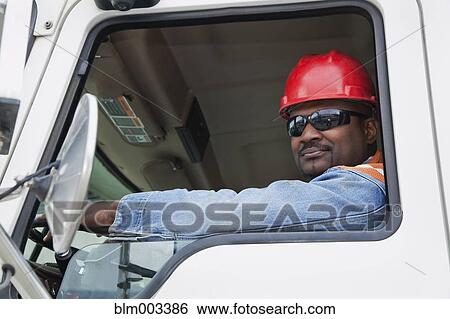 Stock Photograph - African construction worker driving truck. Fotosearch