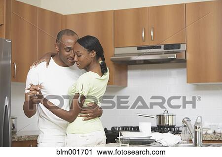 Stock Image - African couple dancing in kitchen. Fotosearch
