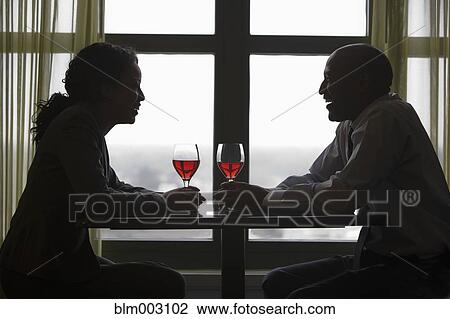 Stock Image - African couple drinking red wine. Fotosearch