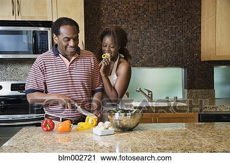 Stock Image - African couple fixing healthy meal in modern kitchen. Fotosearch