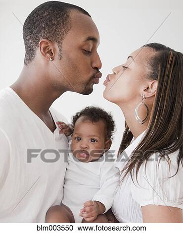 African couple holding baby and kissing View Large Photo Image Stock Image - African couple holding baby and kissing. Fotosearch