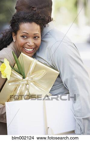 African couple holding gifts and hugging View Large Photo Image Picture - African couple holding gifts and hugging. Fotosearch