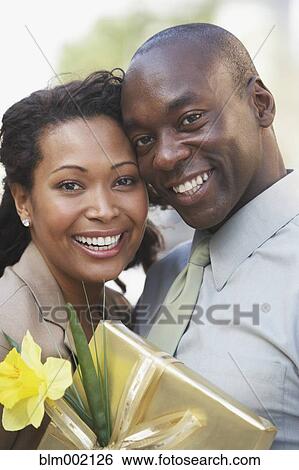 African couple hugging and holding gift View Large Photo Image Stock Photograph - African couple hugging and holding gift. Fotosearch
