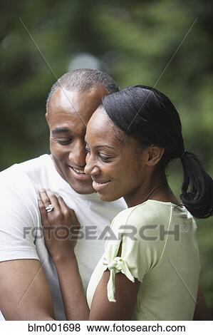 Stock Photo - African couple hugging outdoors. Fotosearch