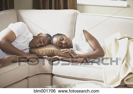 Stock Photograph - African couple sleeping on sofa. Fotosearch