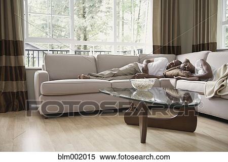 Stock Photography - African couple sleeping on sofa. Fotosearch