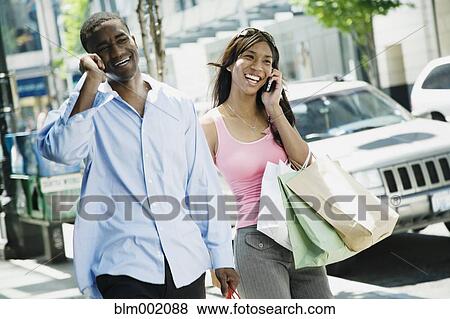 Stock Photo - African couple talking on cell phones. Fotosearch