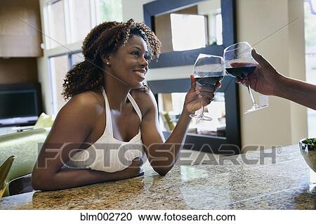 African couple toasting with red wine in kitchen View Large Photo Image Stock Image - African couple toasting with red wine in kitchen. Fotosearch