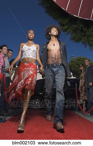 Stock Image - African couple walking on red carpet. Fotosearch