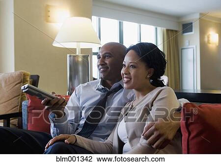 Stock Image - African couple watching television. Fotosearch