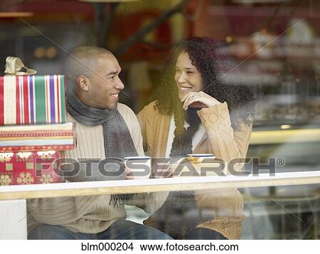 Picture - African couple with presents in coffee shop. Fotosearch