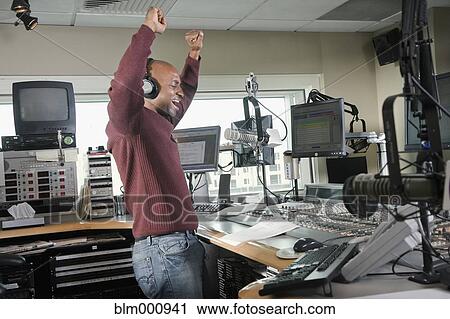 Stock Image - African dj working at radio station. Fotosearch