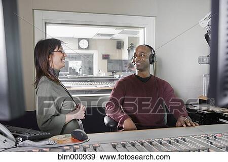 Stock Photo - African dj working at radio station with co-worker. Fotosearch
