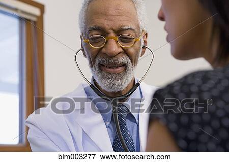 African doctor examining patient View Large Photo Image Stock Photo - African doctor examining patient. Fotosearch