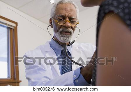 Stock Photograph - African doctor examining patient. Fotosearch