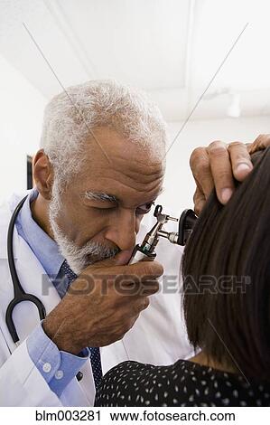 African doctor examining patient's ear View Large Photo Image Stock Image - African doctor examining patient's ear. Fotosearch