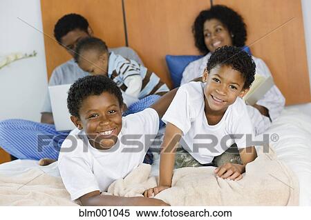 African family laying on bed View Large Photo Image Stock Photography - African family laying on bed. Fotosearch