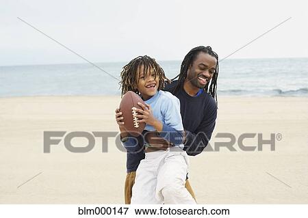 African father an son playing football View Large Photo Image Stock Photo - African father an son playing football. Fotosearch