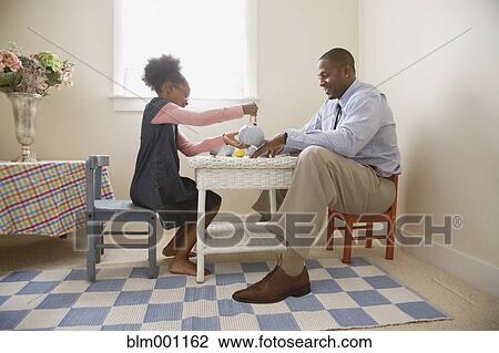 Stock Image - African father and daughter playing tea. Fotosearch