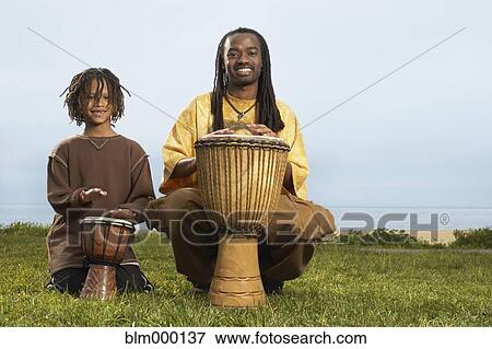 Stock Photo - African father and son playing drums. Fotosearch