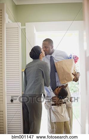 Stock Photo - African father with groceries greeting family. Fotosearch