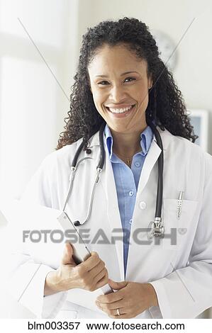 Stock Photo - African female doctor holding medical chart. Fotosearch
